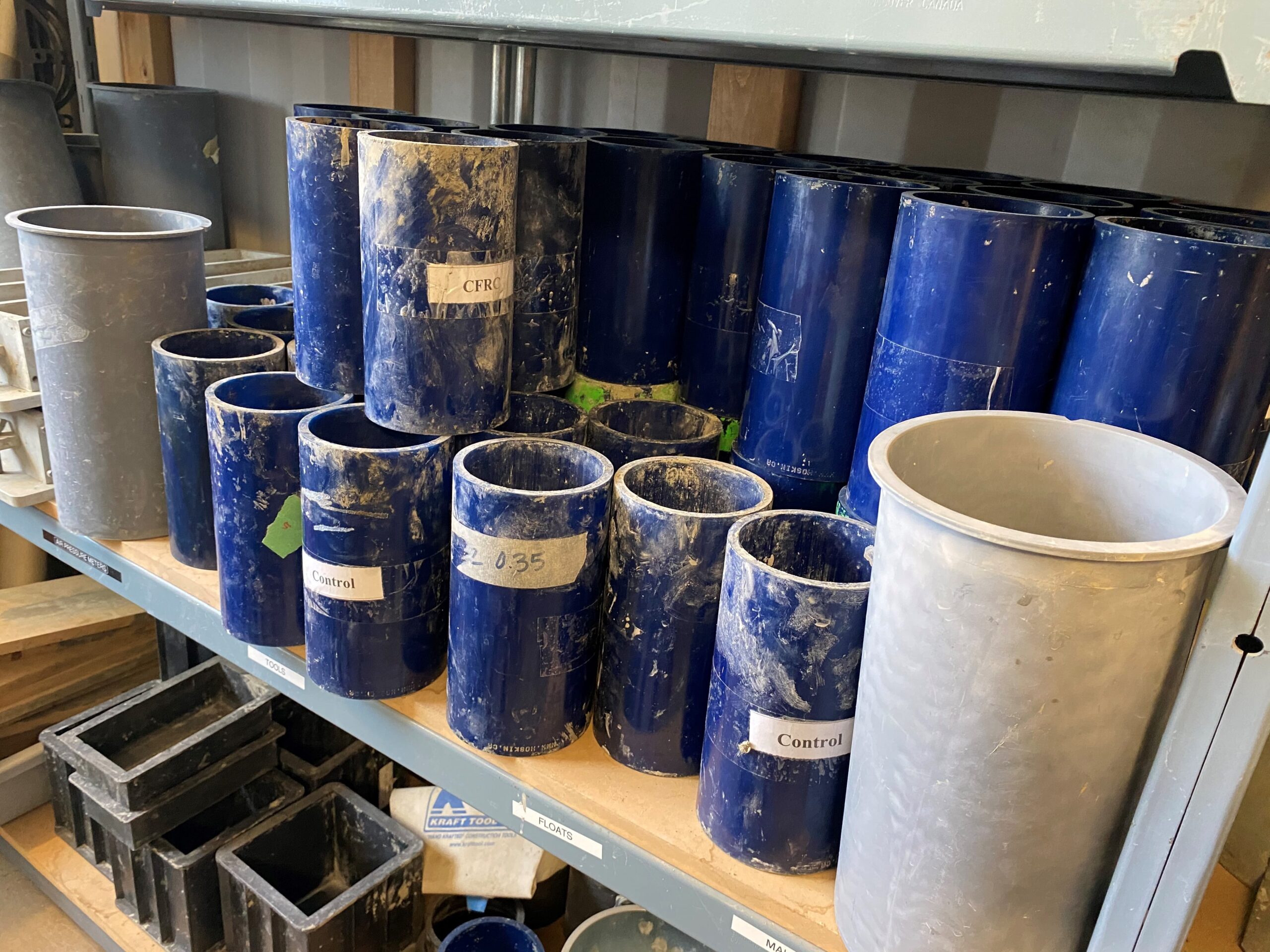 Shelving unit with empty canisters for liquid concrete samples