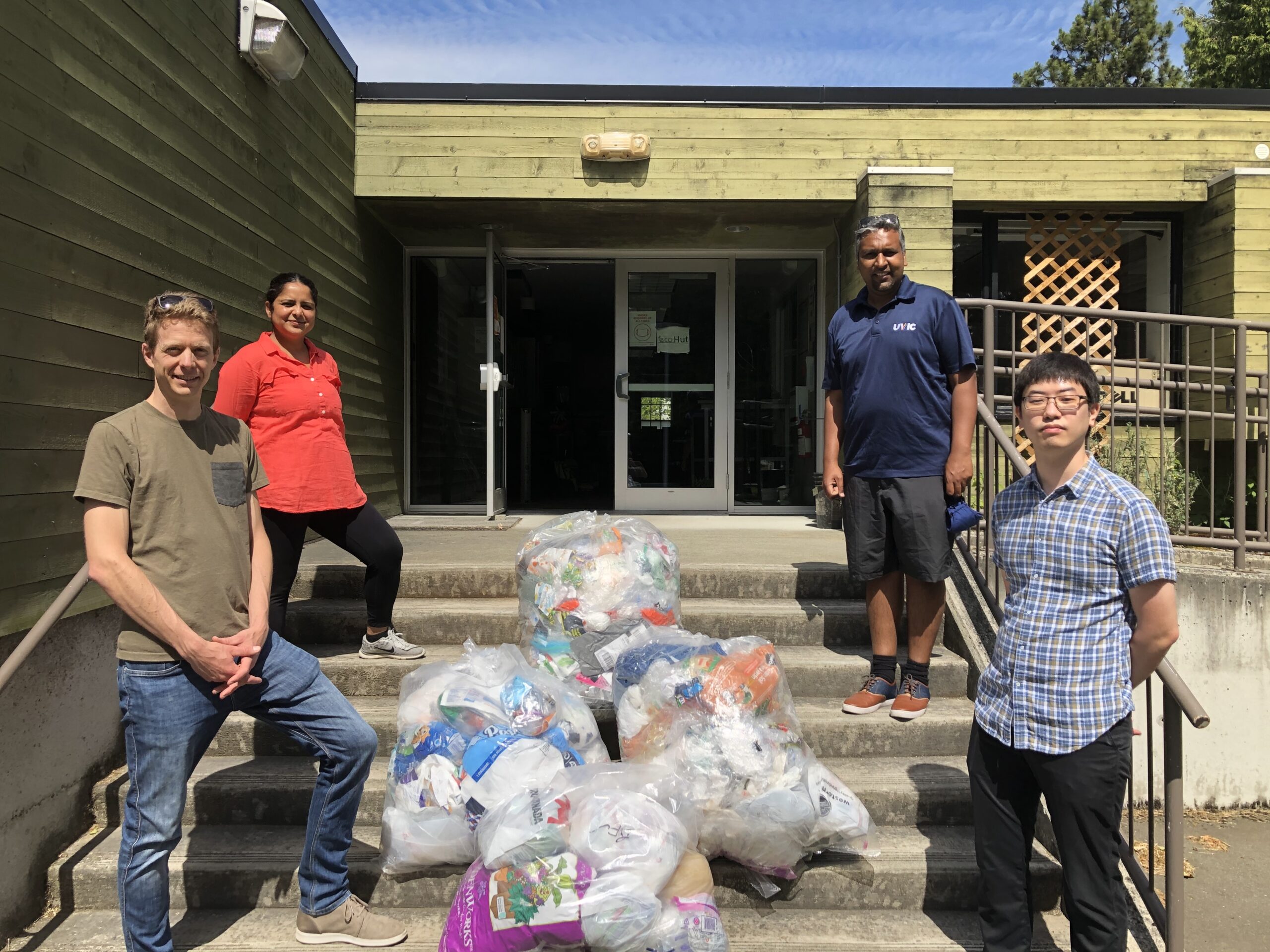 Recycle BC and University of Victoria team posing on stairs with clear plastic bags filled with other flexible plastic packaging